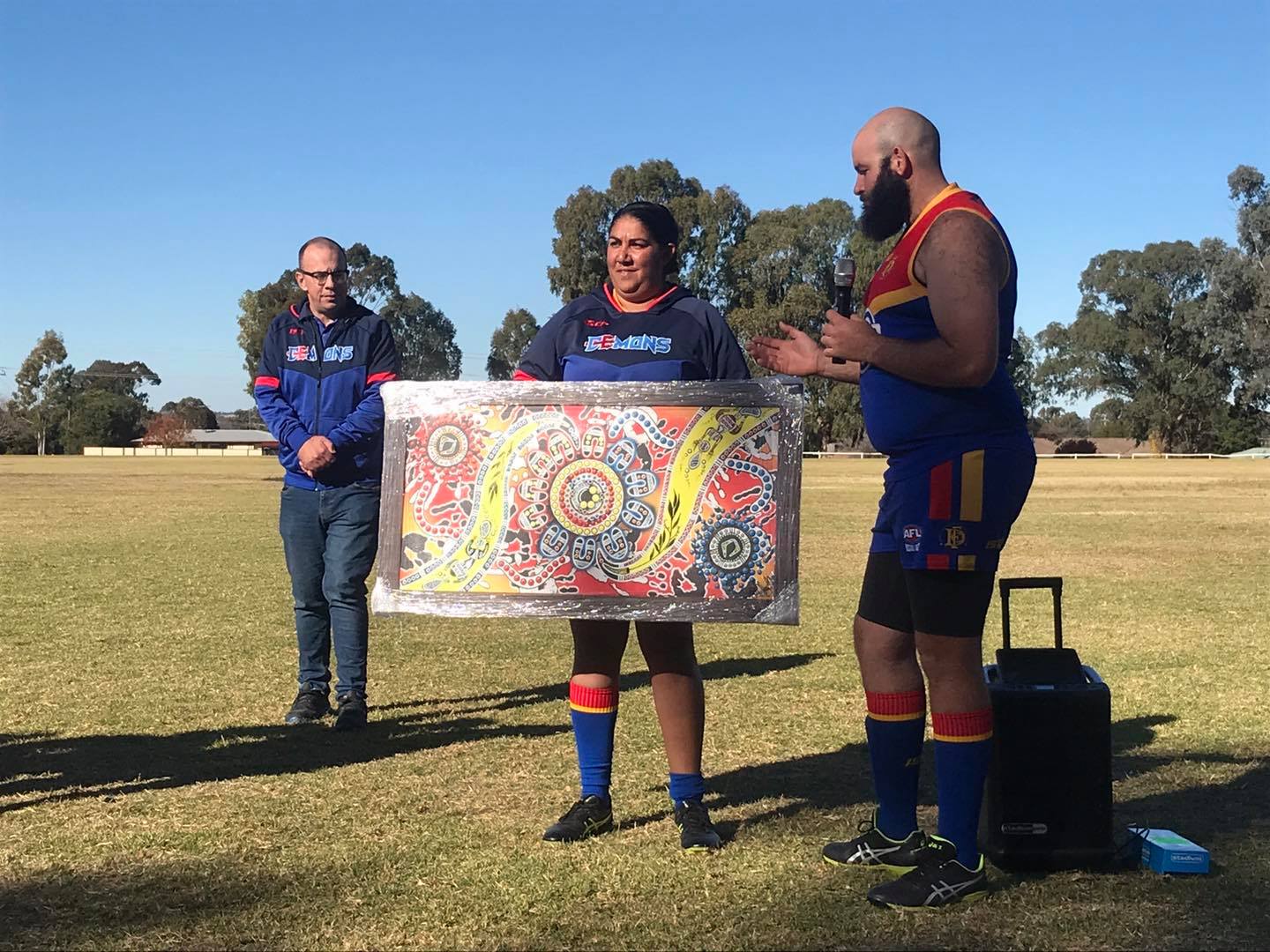 Trudy Sloane presenting Dubbo Demons President Tom Skinner with the artwork used in the design of their Indigenous Guernsey. Photo: AFL Central West